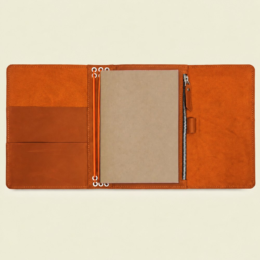 Genuine orange leather notebook cover designed with six elastic bands and practical pockets.