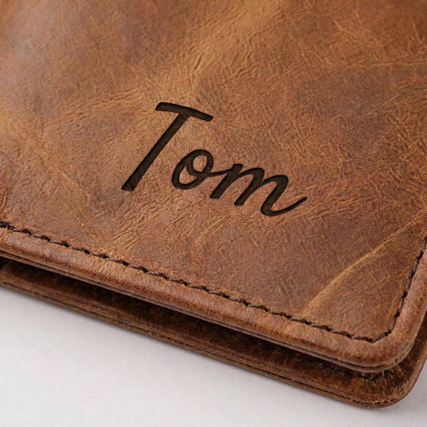 Brown leather journal cover with 'Tom' engraved on a white background
