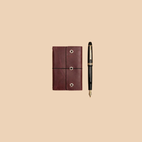 Brown leather cardholder with a pen on a beige background