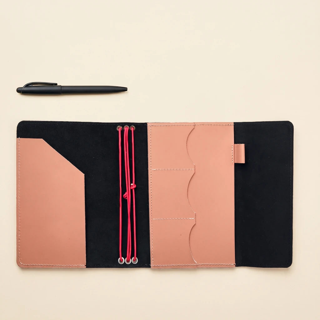 Handcrafted leather notebook cover with elastic bands and built-in writing accessory holder