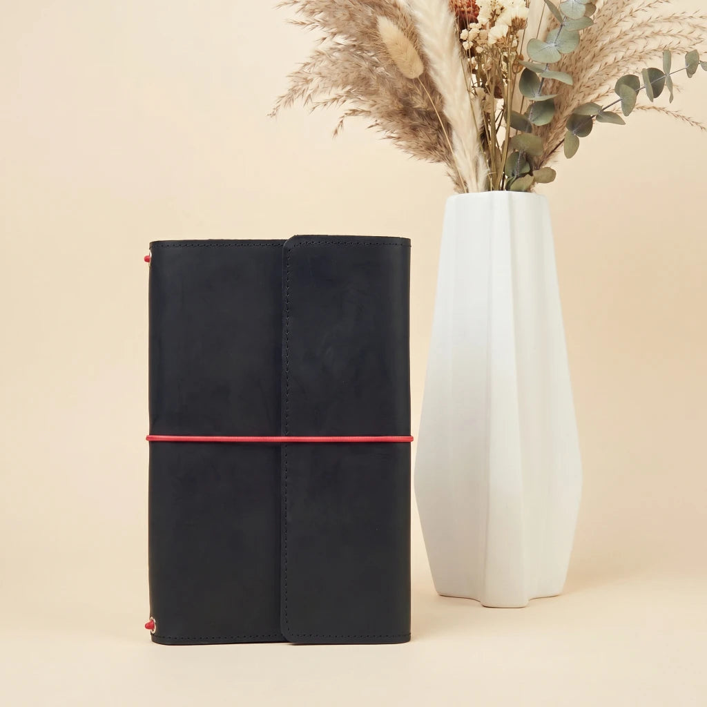 Leather notebook cover with elastic closure, card pockets, and attached pen holder