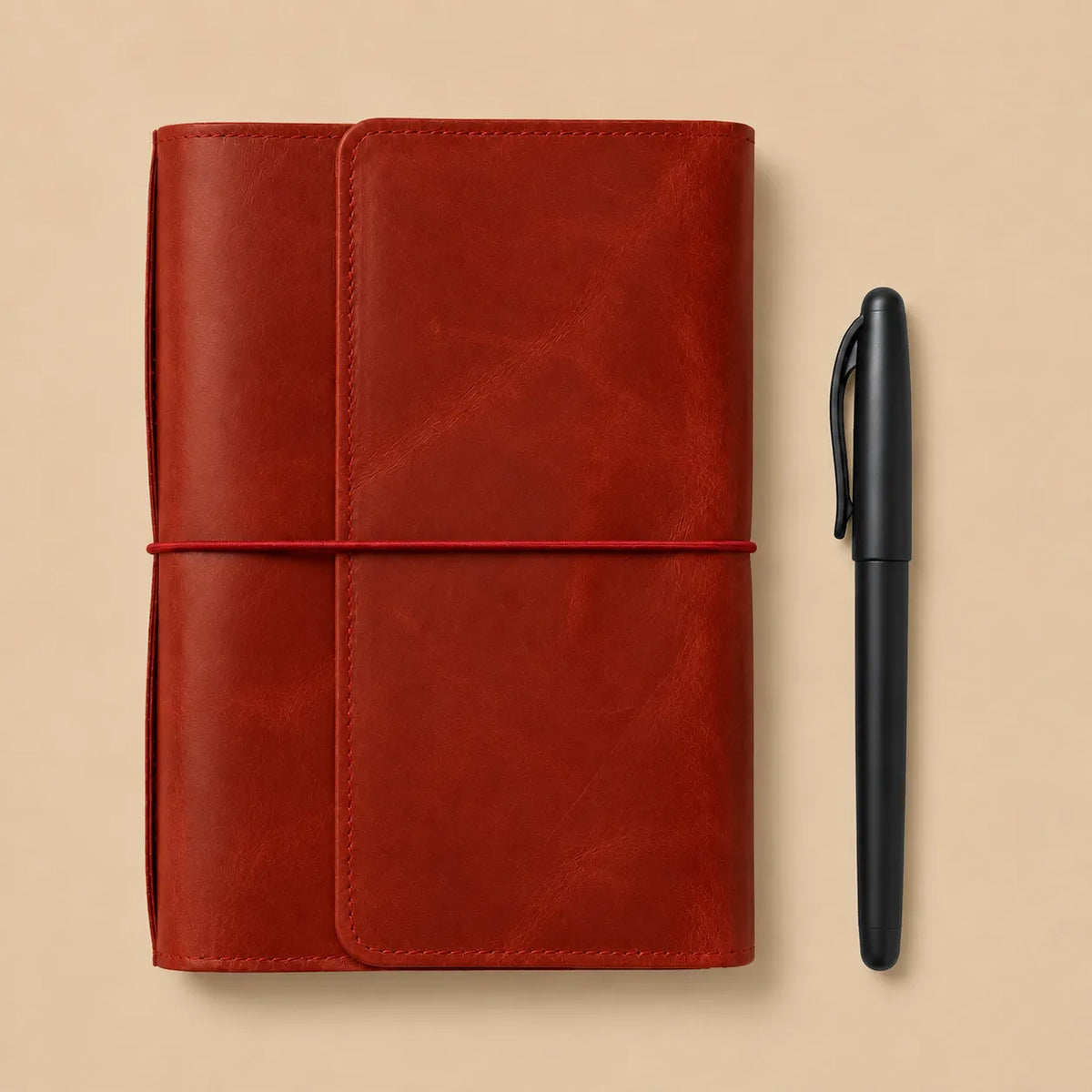 Genuine leather notebook organizer in red with six elastics, storage pockets, zipper pocket, and pen loop.