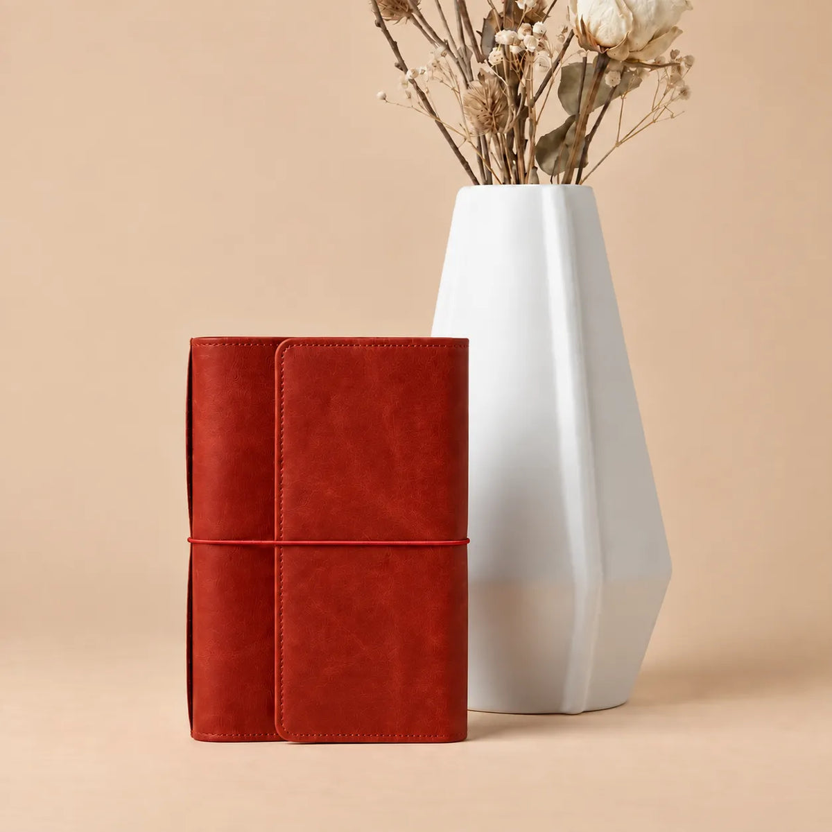 Handmade red leather journal cover featuring six elastics, storage pockets, zipper compartment, and pen holder.