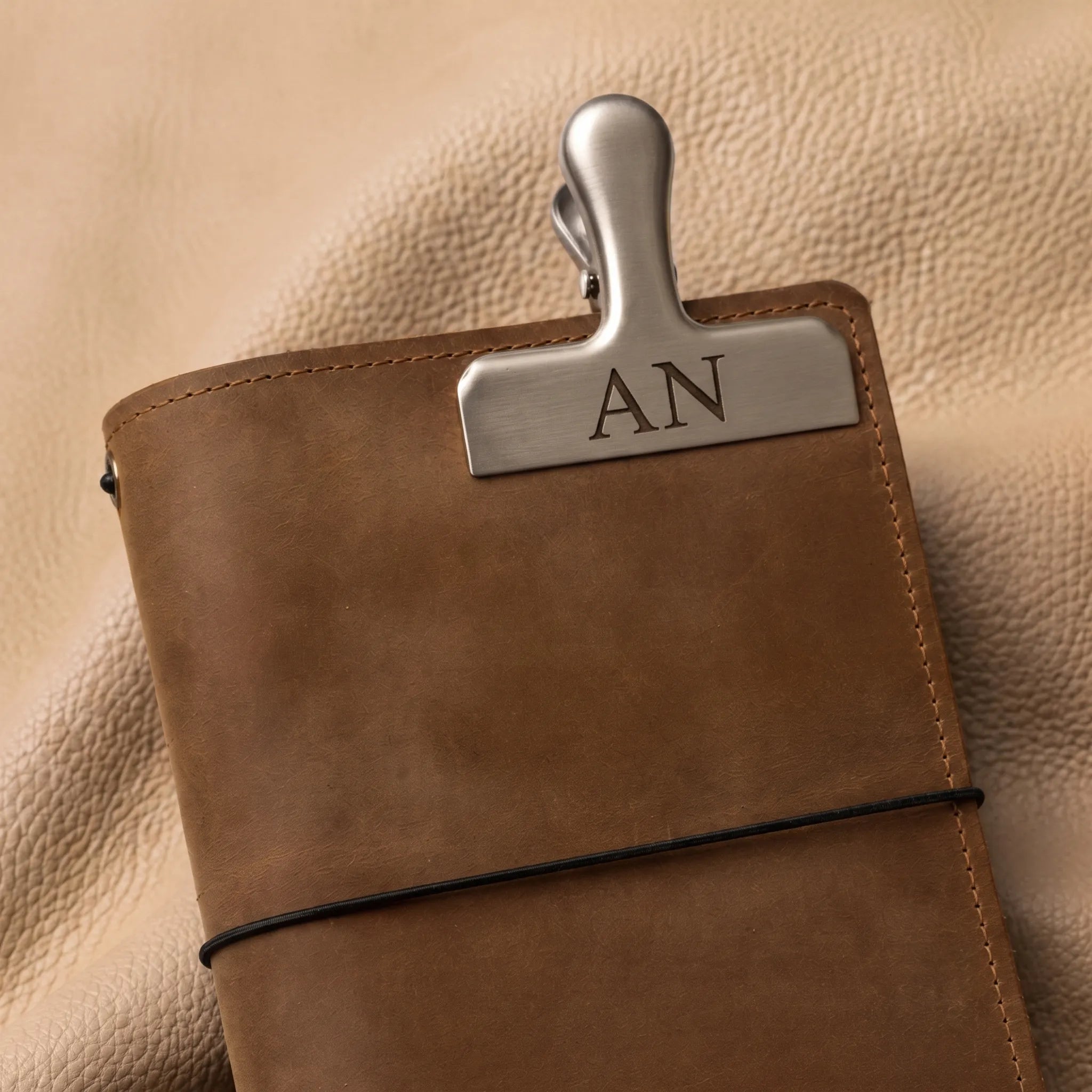 Silver nameplate bookmark clip for leather journals — open view