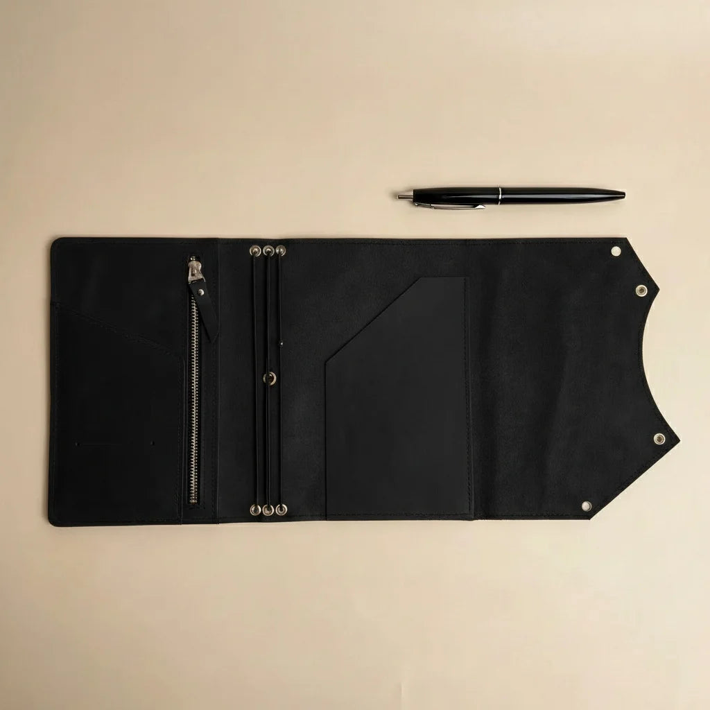 Black leather folio with pen on a beige background