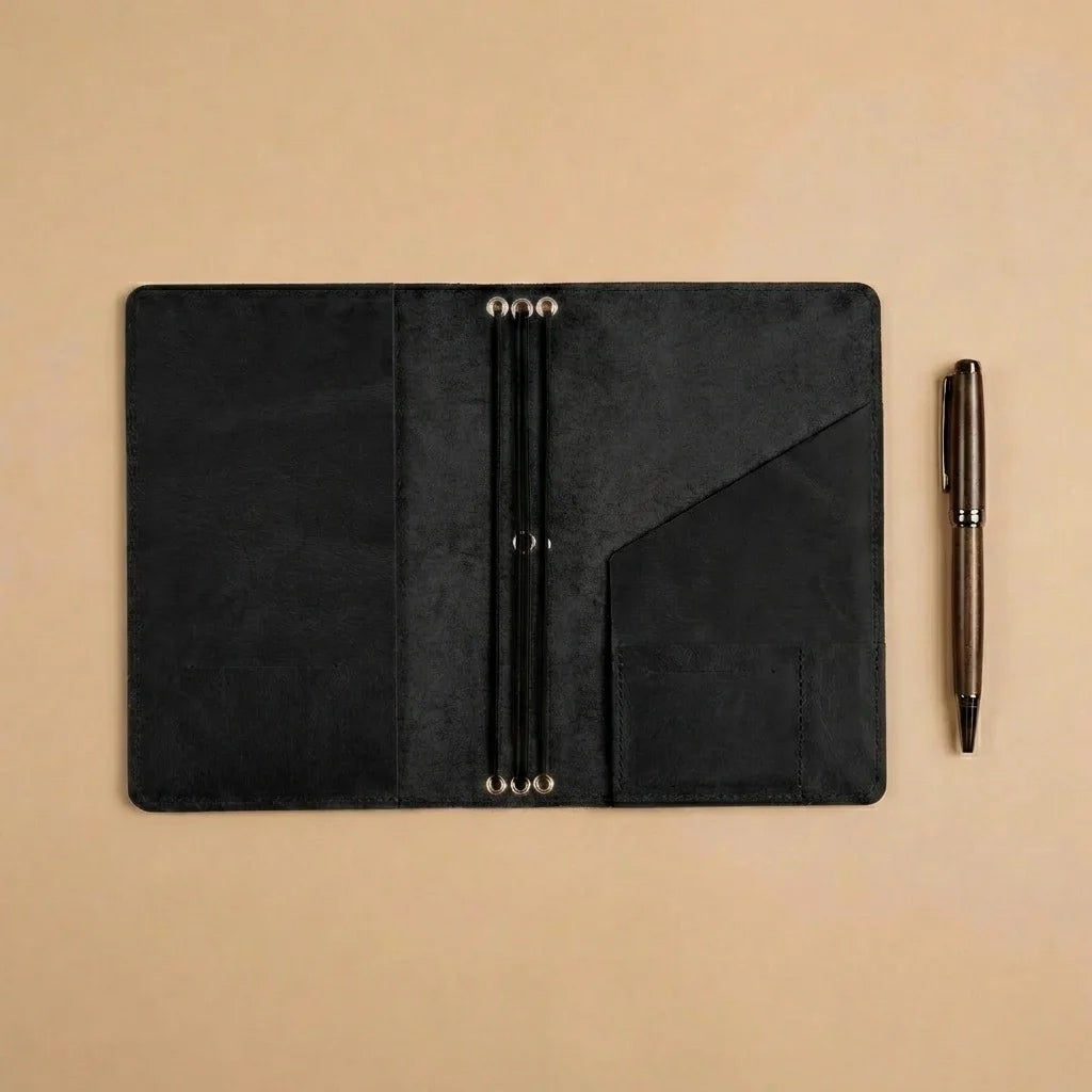 Black leather planner with a pen on a beige background