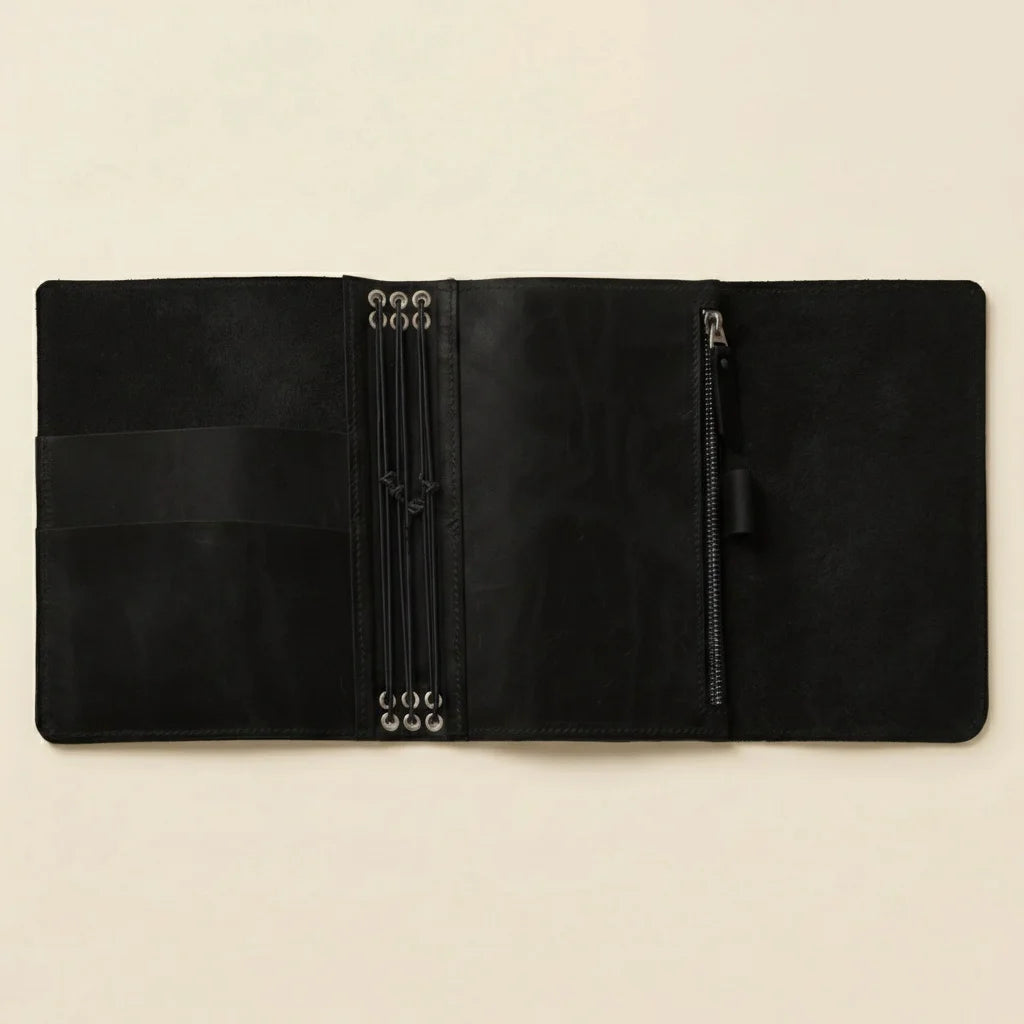 Black leather organizer with zipper on a beige background