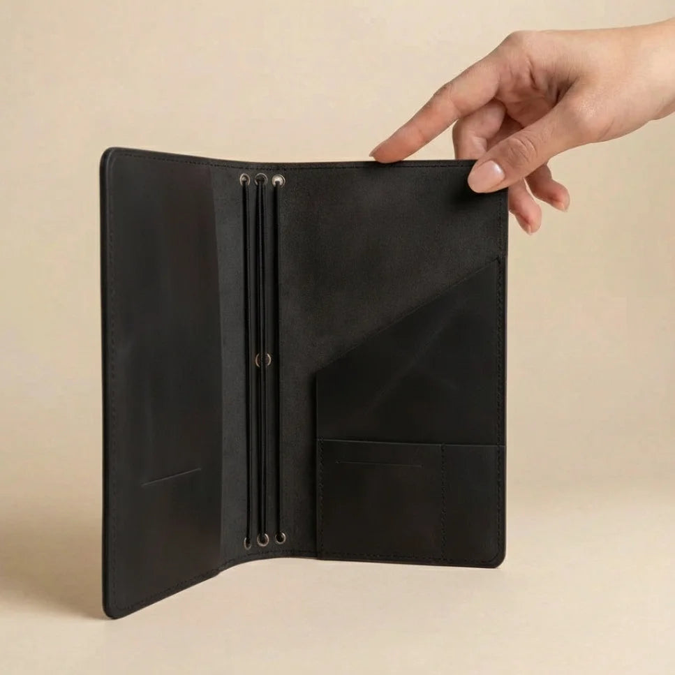 Black leather wallet held open by a hand on a beige background