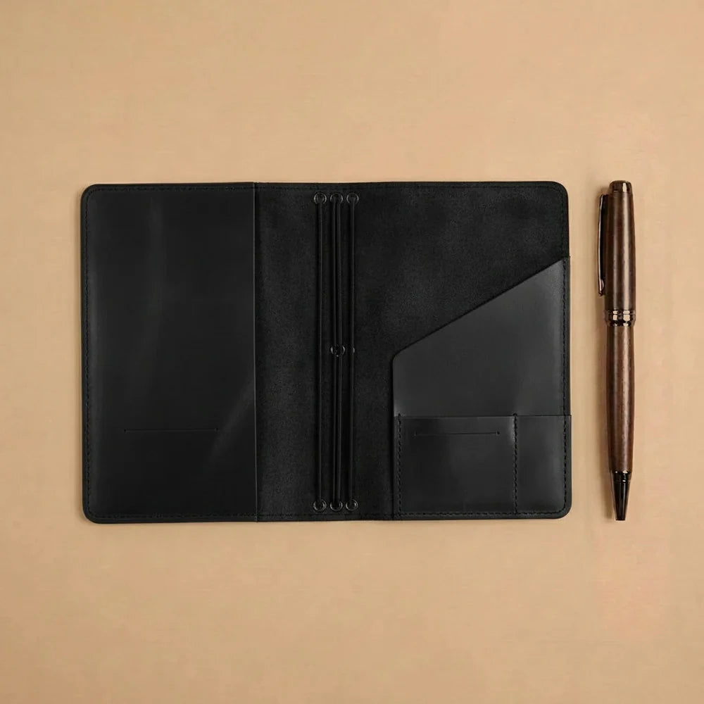 Handmade leather notebook holder with elastic closure system and practical organizer compartments inside.