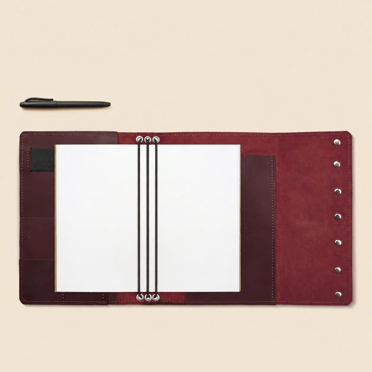Functional leather notebook organizer with inside pockets and attached pen loop.