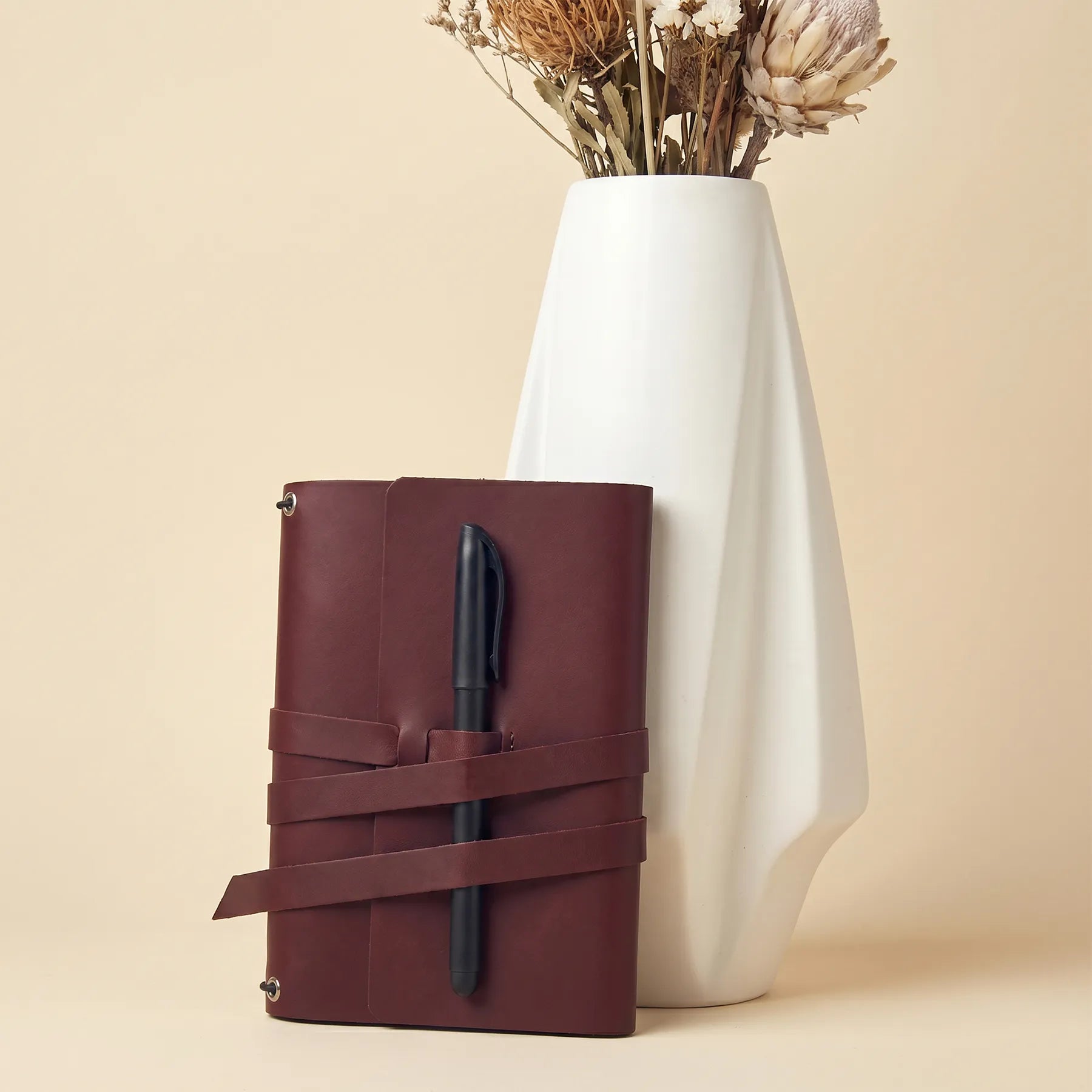 Handcrafted leather notebook cover offering pen holders and stylish protection for journals.