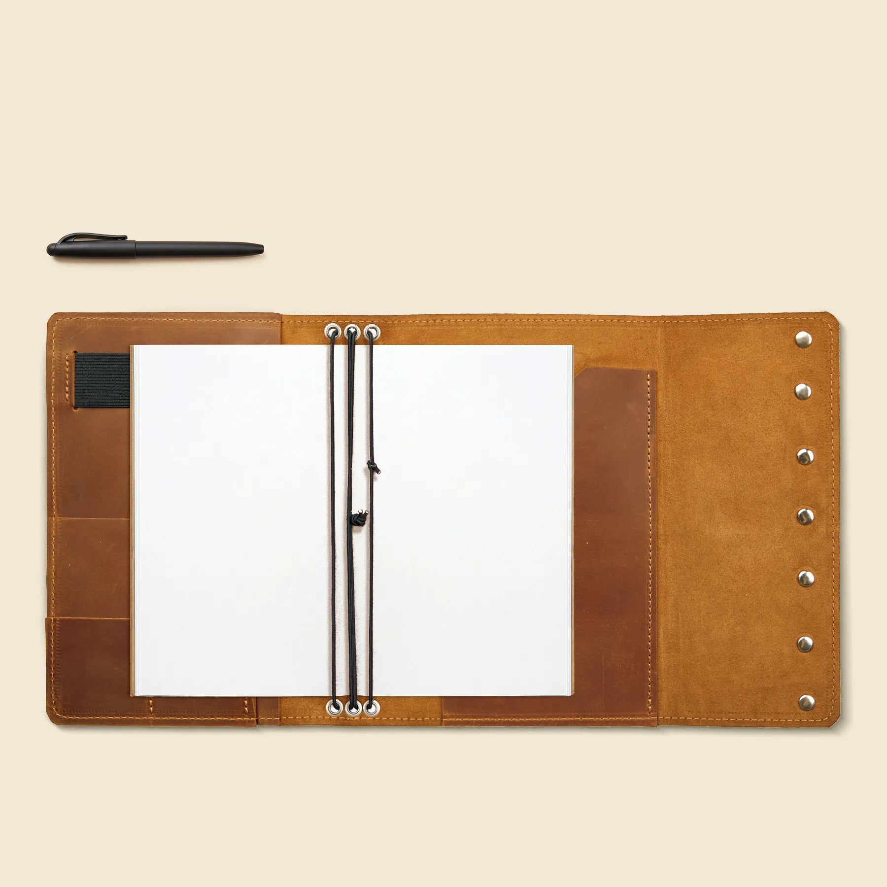 Genuine leather traveler's notebook cover with refillable elastic insert system.