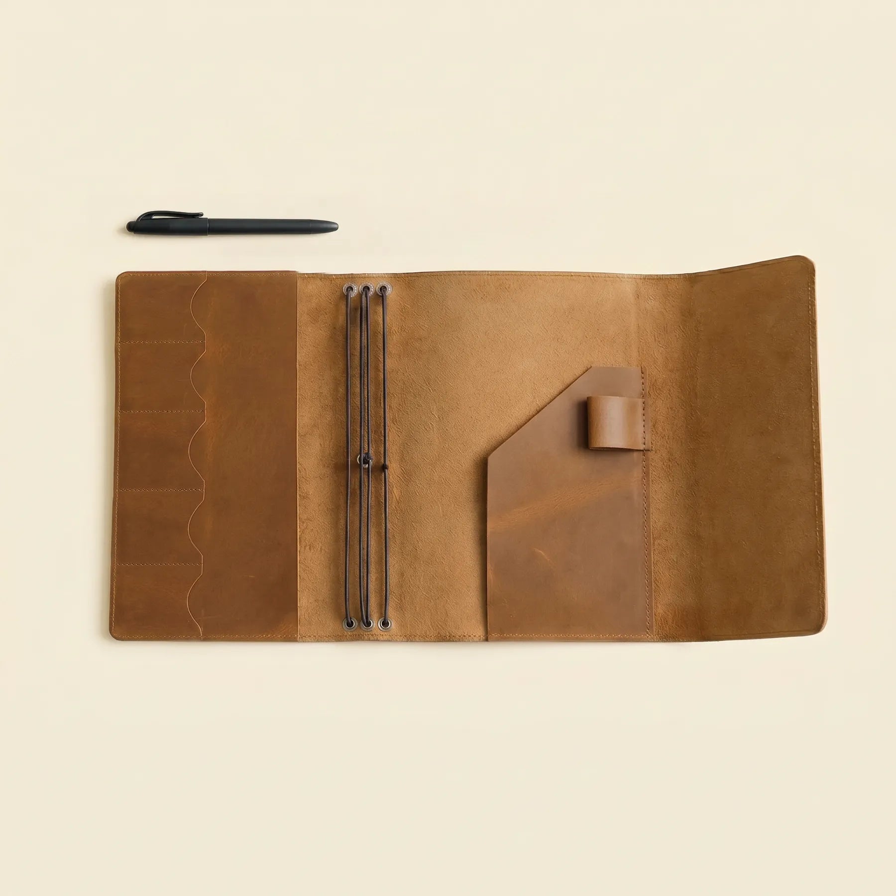 Refillable leather cover with pen loop, card slots, and elastics.