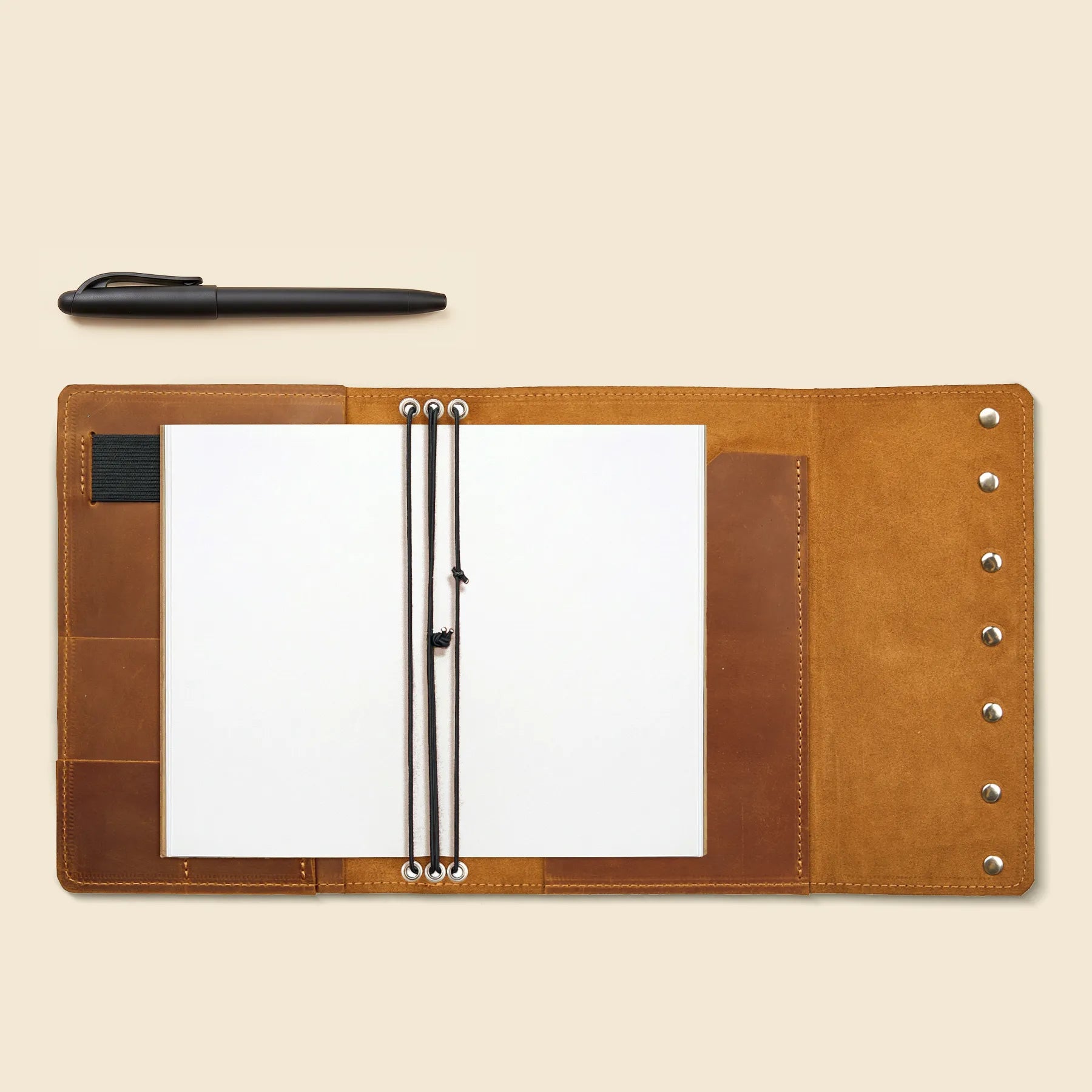 Handmade leather cover featuring multiple notebook elastics and pen holder.