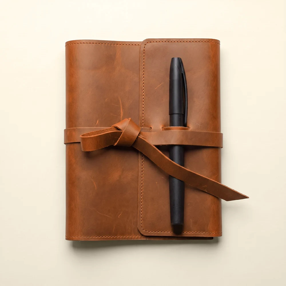 Elegant leather journal cover featuring multiple pockets and a leather pen loop.
