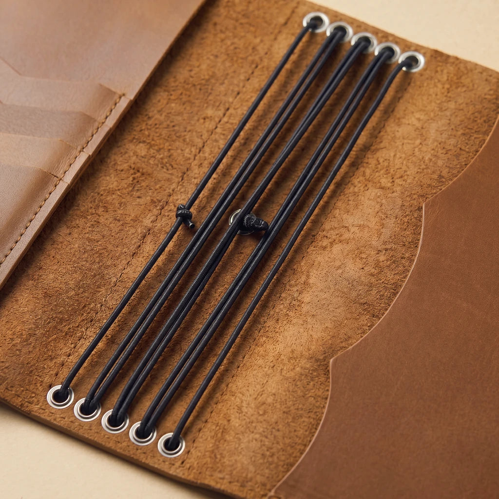 Handmade leather journal cover featuring pen holder and inner pockets