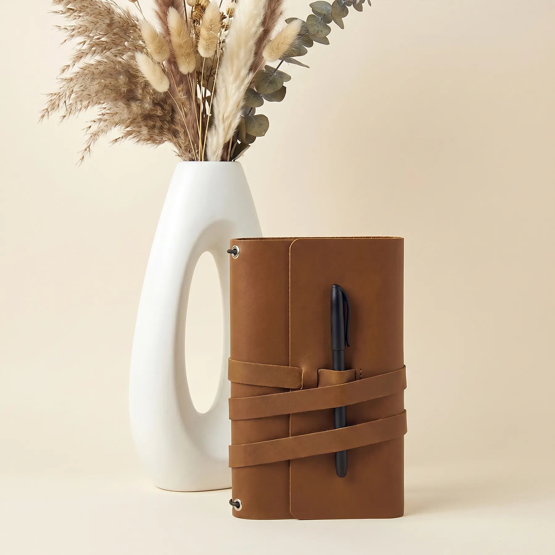 Genuine leather journal cover with integrated pen loops for convenient daily note taking.