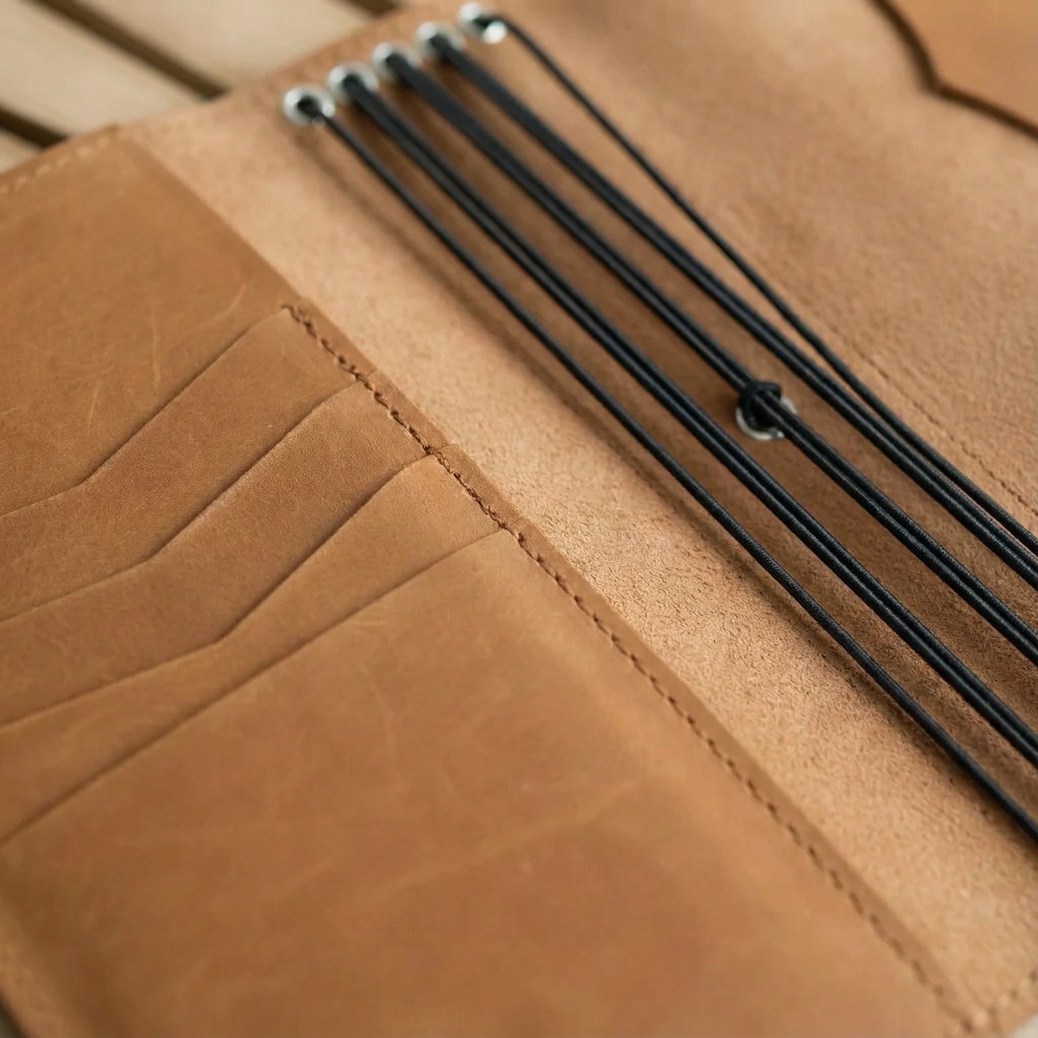 Brown leather notebook on a wooden shelf with a neutral background