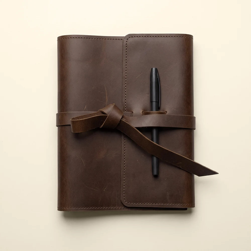 Leather planner cover with organized card pockets and built-in pen holder.