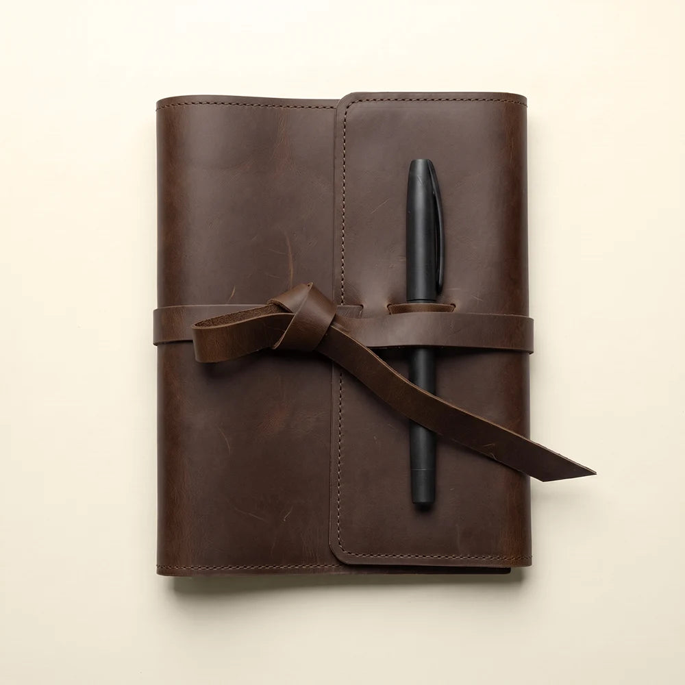 Refillable leather journal cover with interior storage and practical pen holder.