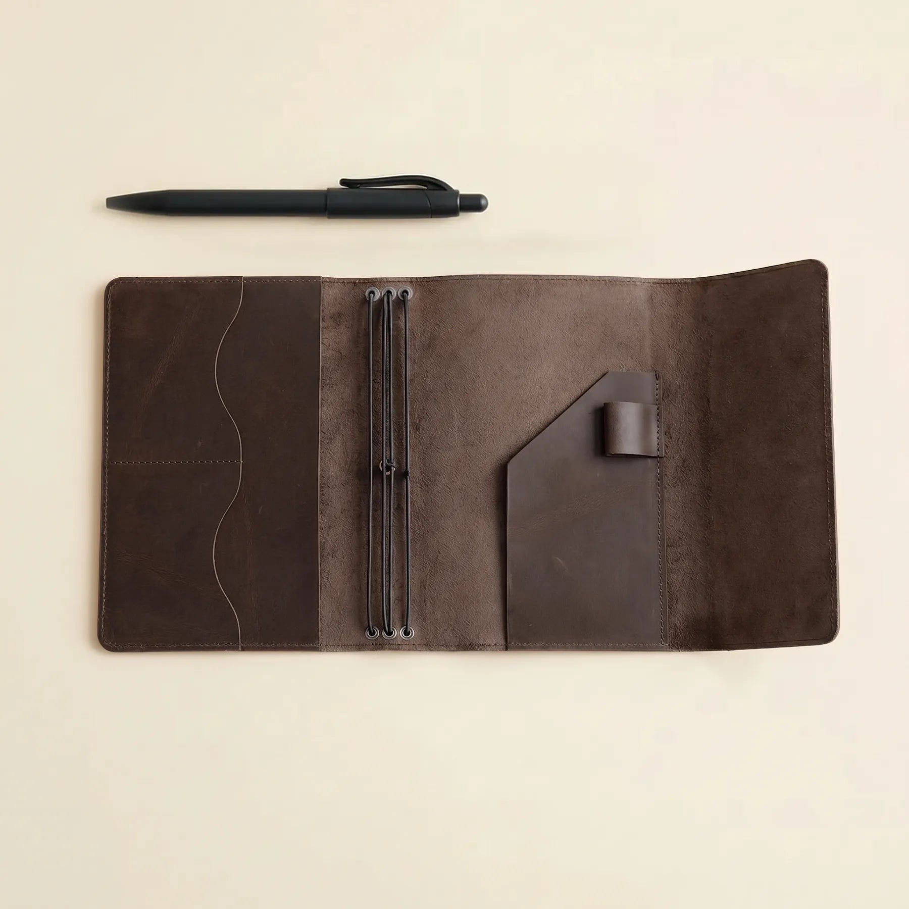Durable leather cover for notebooks with pen loop and card pockets.