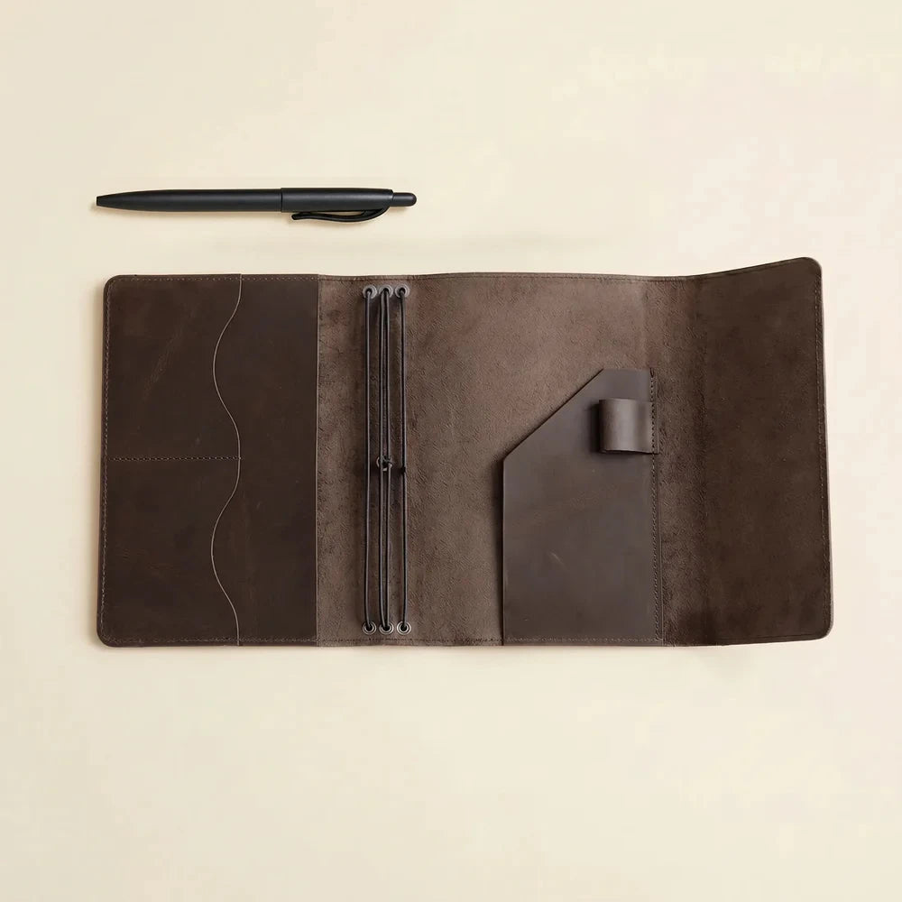 Elegant leather journal cover with elastic notebook holders and spacious interior compartments.