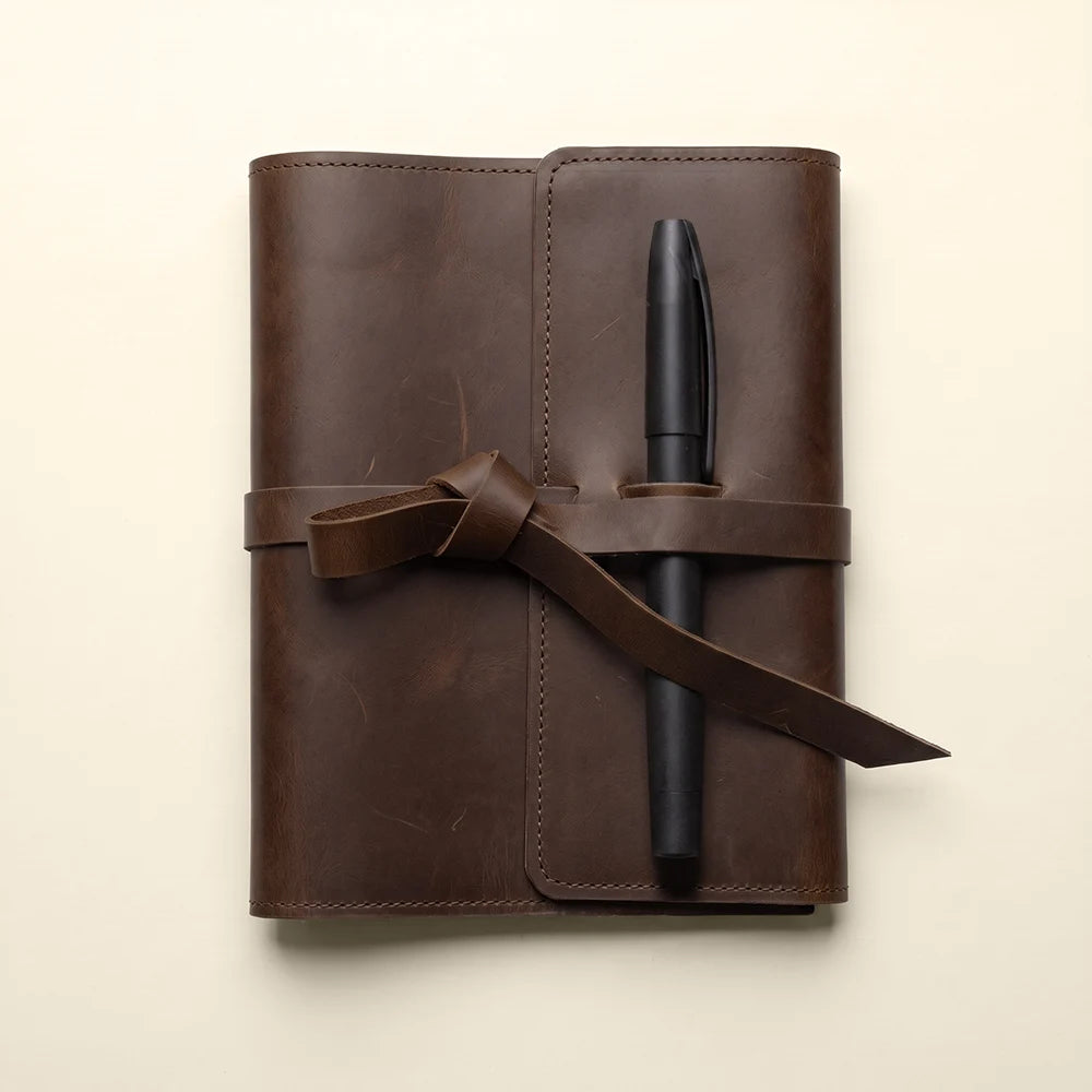 Refillable leather journal organizer with storage compartments and durable pen holder.