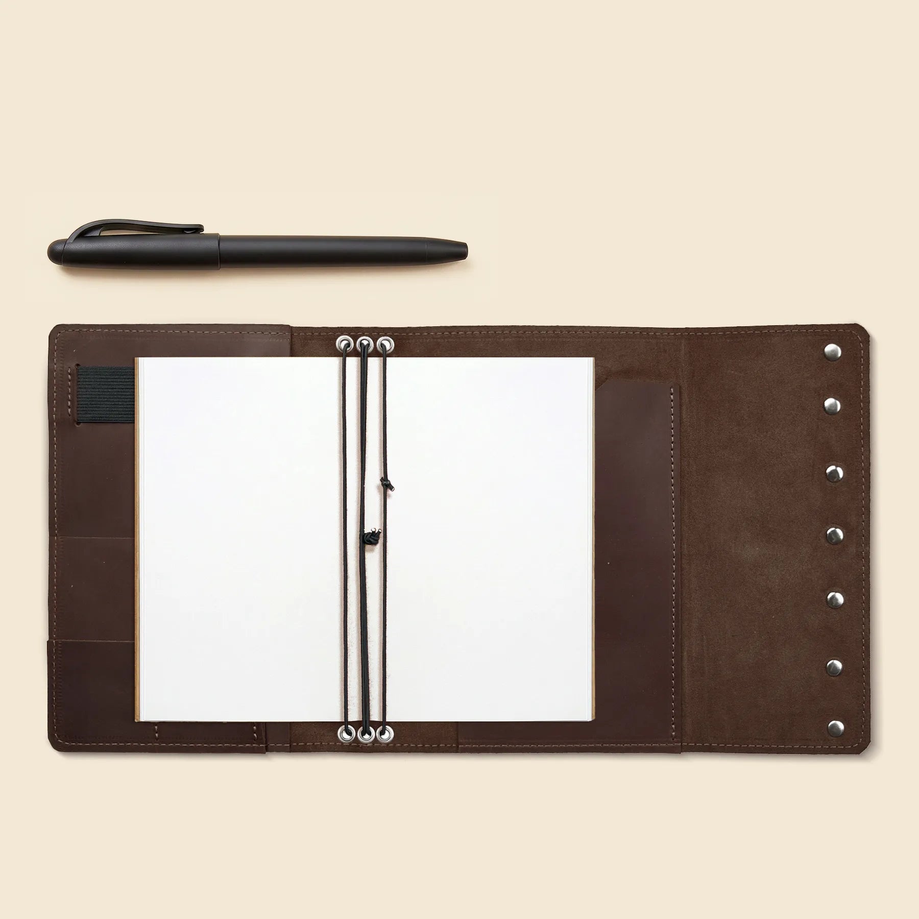 Refillable leather journal cover featuring three elastic bands and inner pockets.