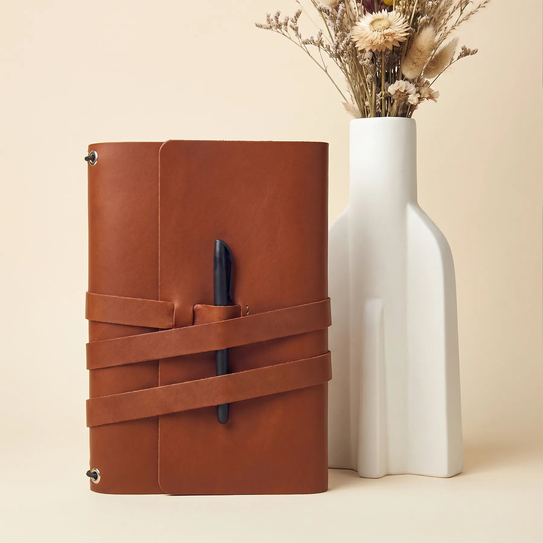 Handmade refillable notebook cover featuring genuine leather and integrated loops for pens.
