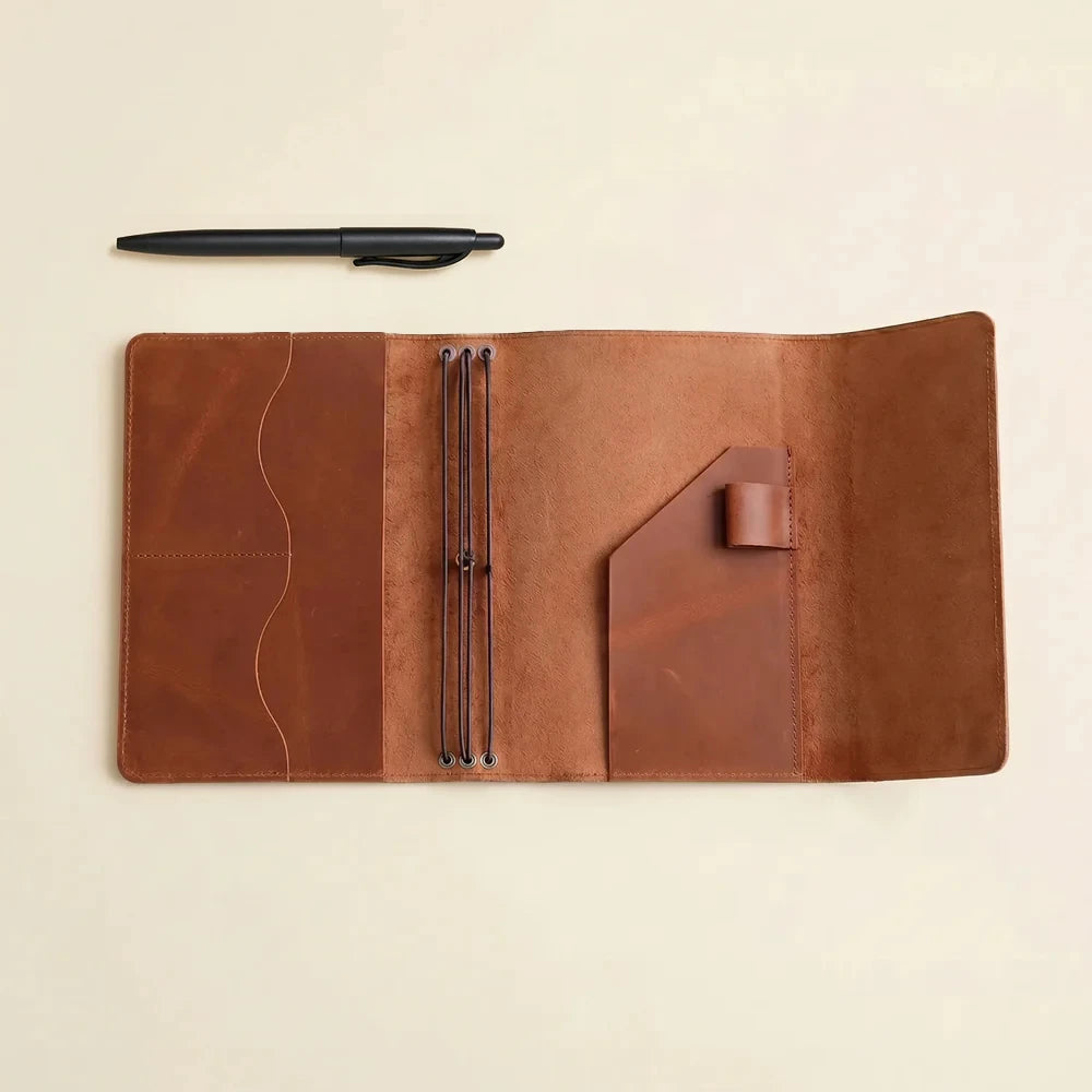Refillable leather notebook organizer with handmade craftsmanship, elastic loops, and storage pockets.