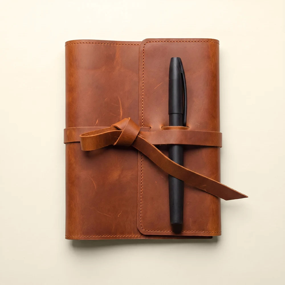 Handmade leather planner cover with functional card pockets and pen loop.