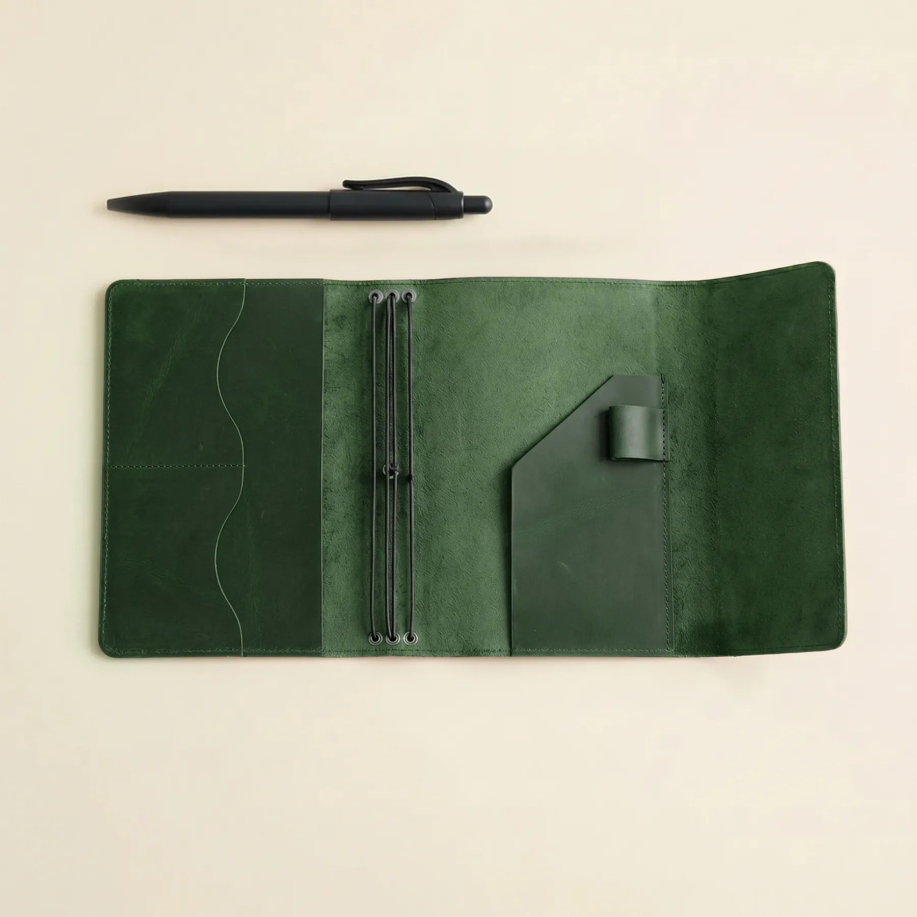 Compact leather notebook cover featuring elastic bands and pen storage.