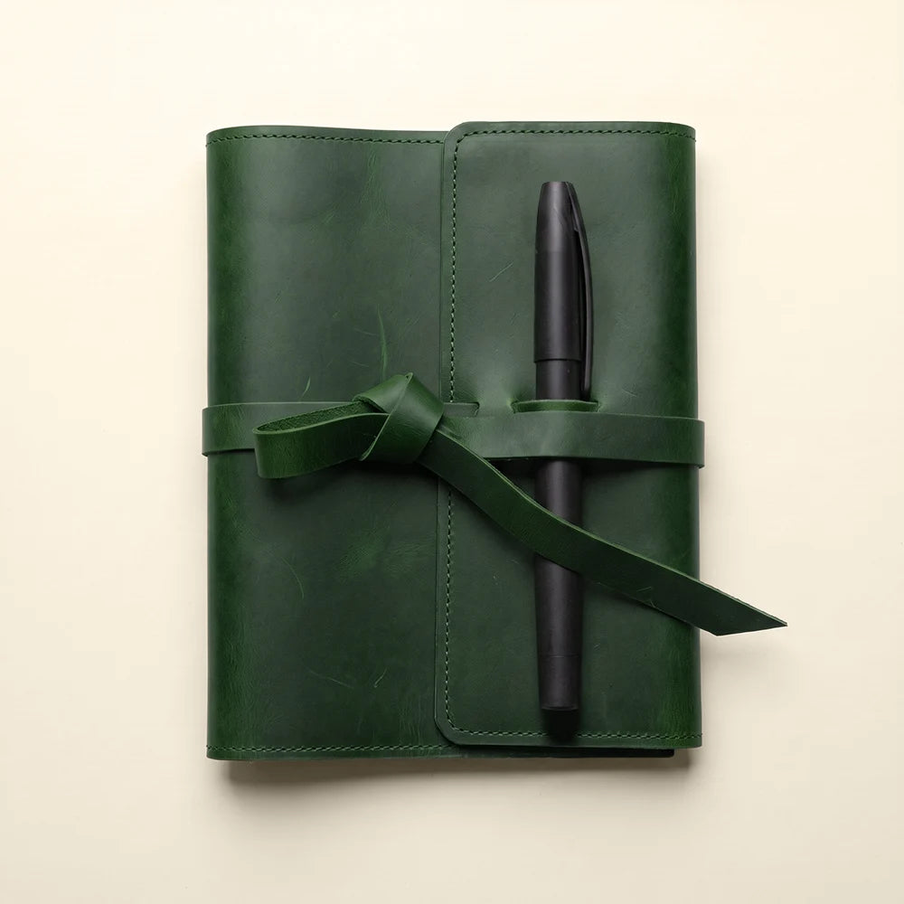 Leather notebook cover designed with card pockets and built-in pen holder.